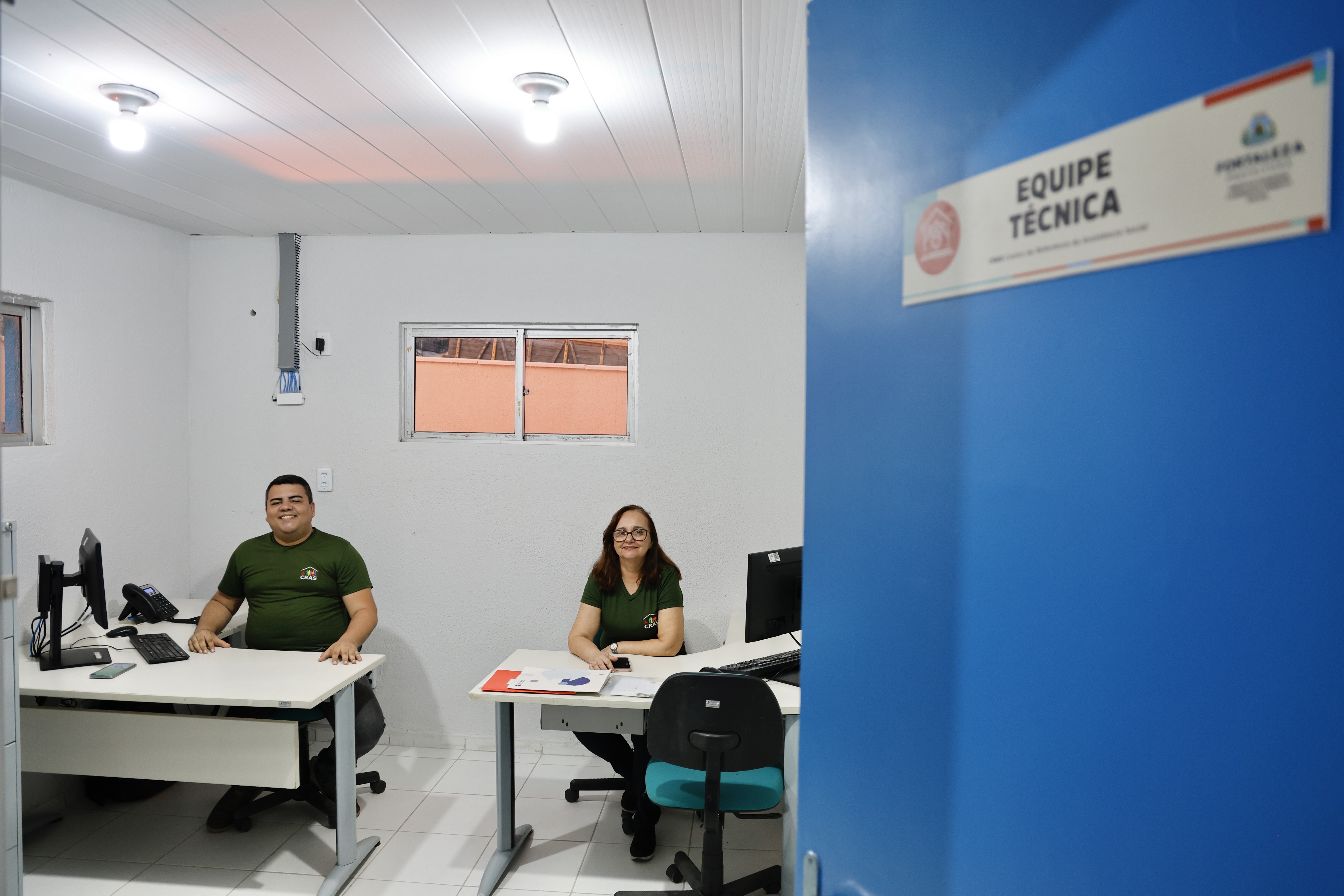 interior de uma das salas de atendimento do cras, com duas pessoas trabalhando em escrivaninhas